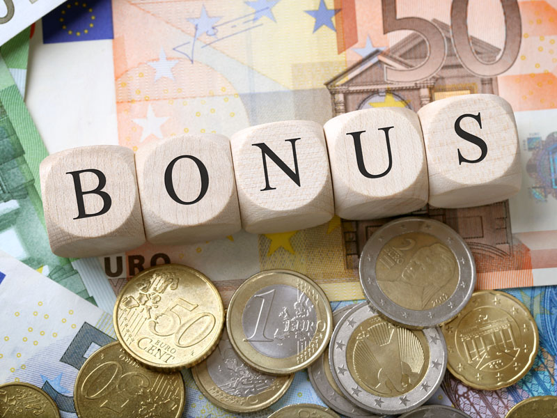 Euroscheine und darüber liegen Würfel, wo Bonus drauf steht